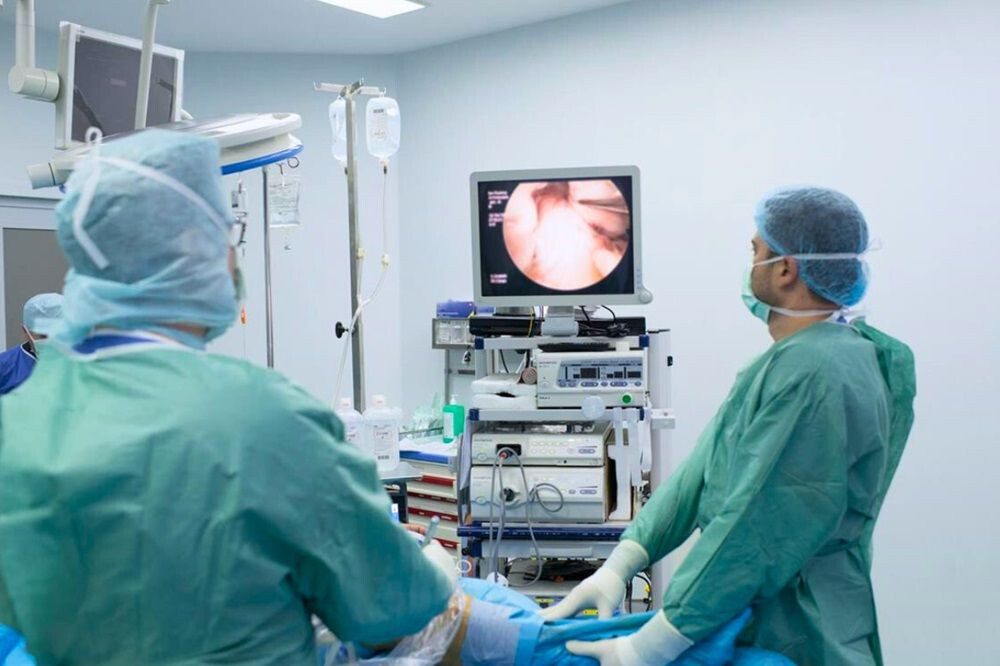 Doi medici realizează o intervenție chirurgicală artroscopică la genunchi, la Spitalul Clinic SANADOR.