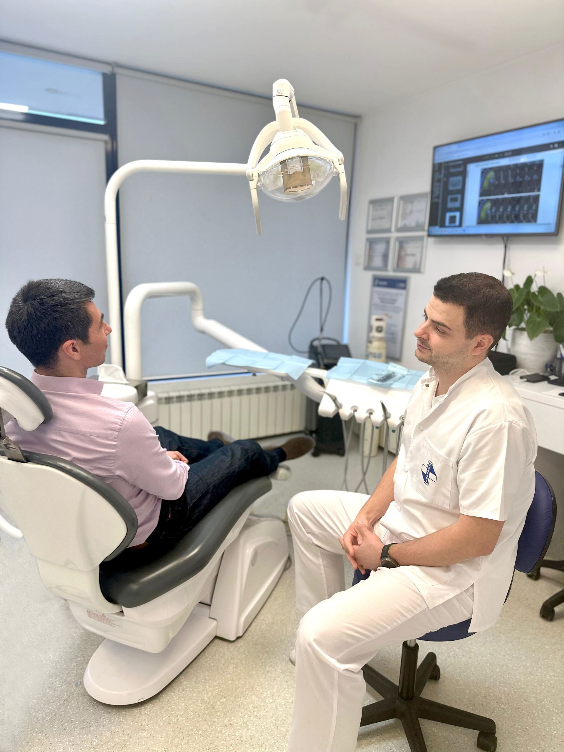 Dr. Bodgan Steriade, medic specialist Protetică dentară la Clinica de Stomatologie SANADOR, alături de pacientul Radu, în timpul consultației.